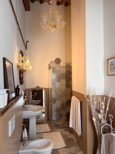 a bathroom with two sinks and a chandelier at Palazzo Ravenna in Ravenna