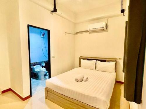 a bedroom with a bed with a towel on it at Silver Oaks Hotel in Patong Beach