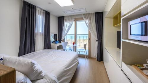 a hotel room with a bed and a television at E7 YangYang Jukdo - Yangyang Stay Dongsan in Saetchak