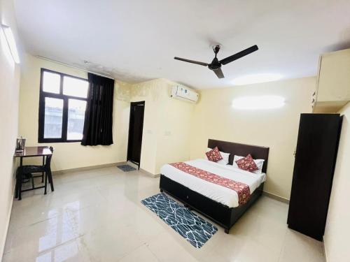 ein Schlafzimmer mit einem Bett und einem Schreibtisch in der Unterkunft Hotel Blueberry - Noida sector 34 Metro in Noida