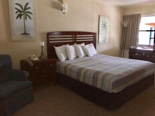 a bedroom with a large bed with white pillows at Dinner Bell Motel in Dunnellon