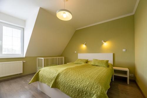 a bedroom with a large bed with a yellow bedspread at Apartments Hradný Mur in Bojnice