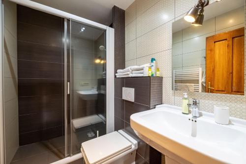 a bathroom with a sink and a shower and a toilet at Apartments Hradný Mur in Bojnice