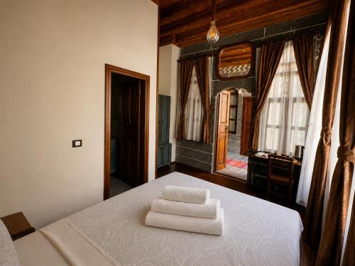 a bedroom with a bed with two towels on it at Taş Avlu Konaklama Tesisi in Diyarbakır