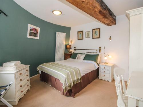 a bedroom with a bed and a green wall at Hadley Park Windmill in Telford