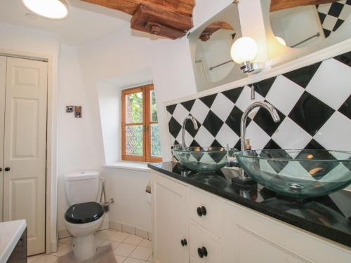 a bathroom with two glass sinks and a toilet at Hadley Park Windmill in Telford