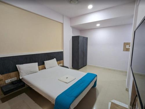 a bedroom with a large bed with a blue blanket at Hotel Sai Leela in Amarnāth