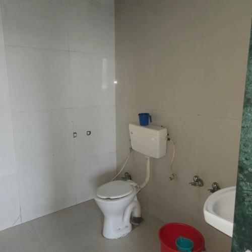 a white bathroom with a toilet and a sink at Hotel Sai Leela in Amarnāth