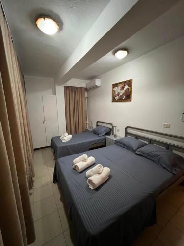 two beds in a room with towels on them at Alira Rooms in Pogradec