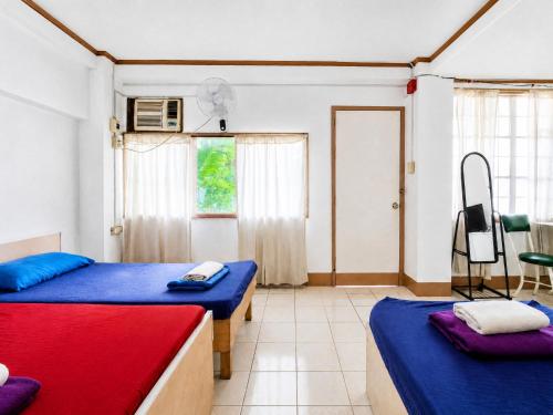 a room with two beds and a tv in it at EnPensionne Hotel in Iloilo City