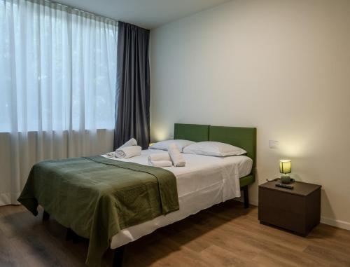 a bedroom with a bed and a large window at SPACE101 City Apartment & Studio in Limito di Pioltello