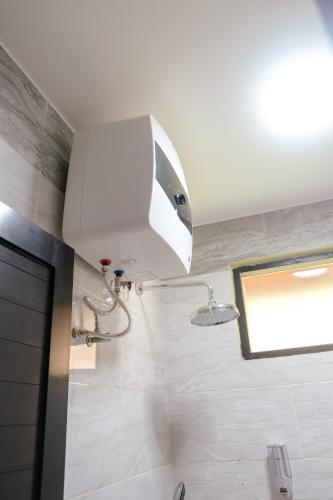 a bathroom with a shower with a white ceiling at Teras Bumi Cabin in Haurkuning
