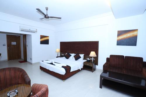 a hotel room with a bed and a couch at Hotel Kohinoor, Bharuch in Bharūch