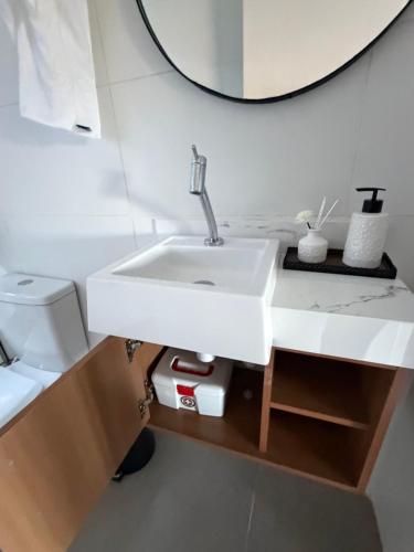 a bathroom with a white sink and a mirror at Refúgio Deusmideu in São Bento do Sapucaí