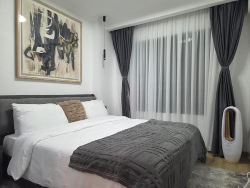 a bedroom with a bed and a large window at Smart Cloud Apartment in Nairobi