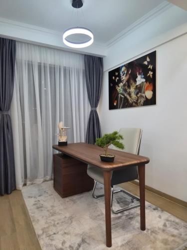 a home office with a wooden desk and a potted plant at Smart Cloud Apartment in Nairobi