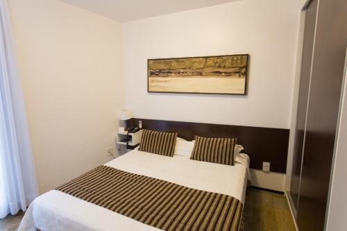 a bedroom with a bed and a painting on the wall at Hotel Brasil Tropical in Fortaleza
