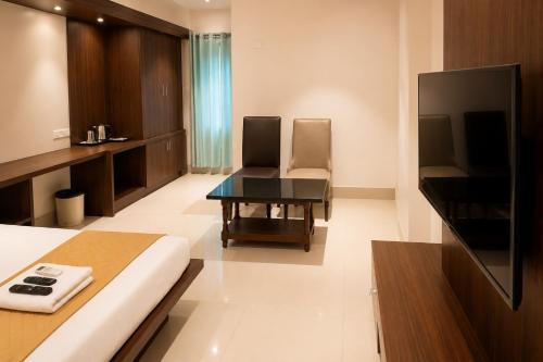 a bedroom with a bed and a desk and a tv at SRS Jade Empire in Kammasandra