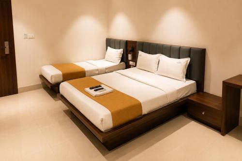 two beds in a hotel room with at SRS Jade Empire in Kammasandra