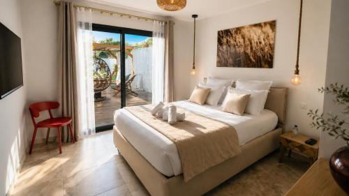 a bedroom with a large bed and a balcony at Villas Vallée d'ASCO in Moltifao
