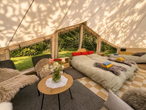 ein Schlafzimmer in einem Zelt mit einem Bett und einem Tisch in der Unterkunft Eden Baths in Averoy