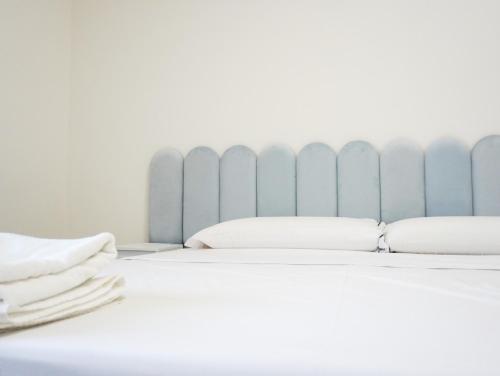 a bed with white pillows and a blue radiator at La Martina Guesthouse in Angri