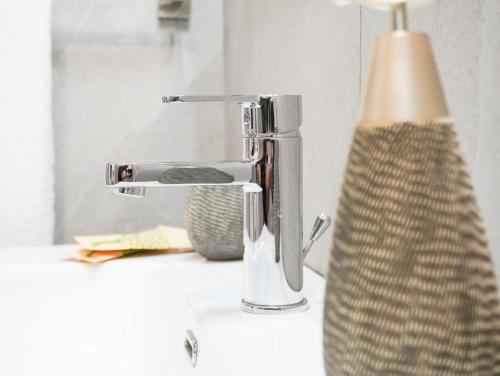 a bathroom sink with a faucet and a vase at La Martina Guesthouse in Angri