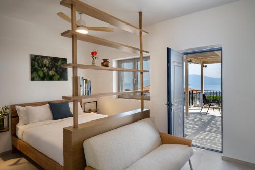a bedroom with a bed and a chair and a balcony at Trigono Suites - Karat in Politika