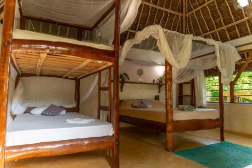 a bedroom with two bunk beds in a house at Distant Relatives Ecolodge & Backpackers in Kilifi