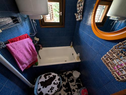 a blue bathroom with a tub and a toilet at Kremna Cottage in Kremna
