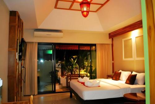 a bedroom with two beds and a large window at Oopkaew Resort in Pua