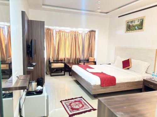 a bedroom with a bed and a desk in a room at JB Residency By Rio Grande in Tiruchirappalli
