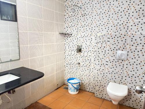 a bathroom with a toilet and a sink and a mirror at JB Residency By Rio Grande in Tiruchirappalli
