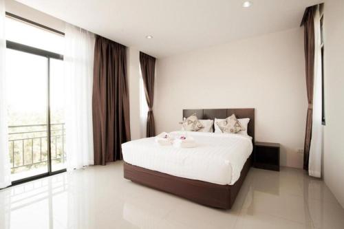a bedroom with a large bed with two pink ducks on it at The Viewpoint Hotel in Ban Wat Tha Maprang