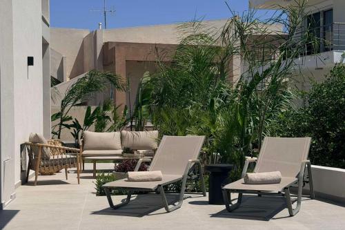 a group of chairs sitting on a patio at Mirena Exclusive Apartments in Afantou