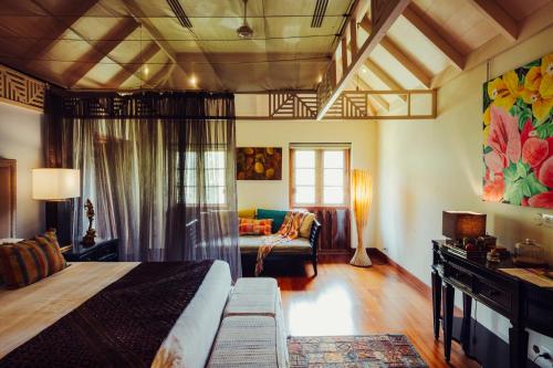 a bedroom with a bed and a couch in a room at Indian Summer House in Mūvattupula