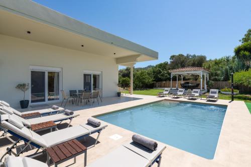 a swimming pool with chairs and a gazebo at Cielo Hillside Villa in Ialysos