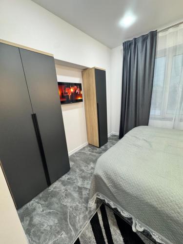 a bedroom with a bed and a large window at APARTMENT Ultra central in Edineţ