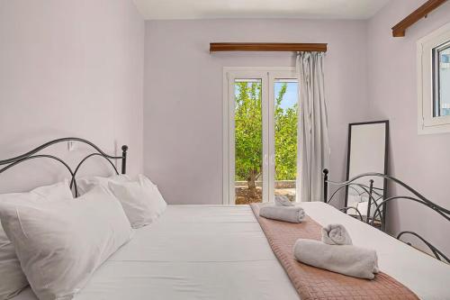 a bedroom with a white bed with white pillows at Alkioni Sea View Apartment in Kato Zakros