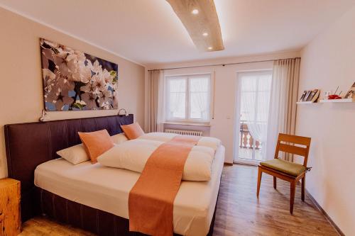 a bedroom with a large bed and a chair in it at Schiebenrothenhof in Simonswald