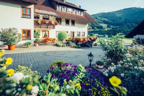 a garden in front of a building with flowers at Schiebenrothenhof in Simonswald
