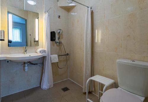 a bathroom with a shower and a toilet and a sink at B&B HOTEL Strasbourg Nord Artisans in Vendenheim