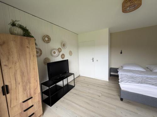 a bedroom with a bed and a flat screen tv at Gemütliche Ferienwohnung direkt am Waldrand in Dörentrup