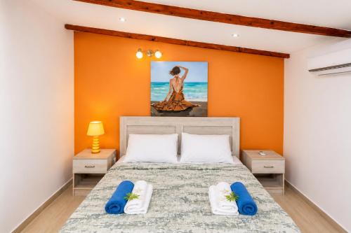 a bedroom with a bed with an orange wall at Cavo Prima Kiotari in Gennadi