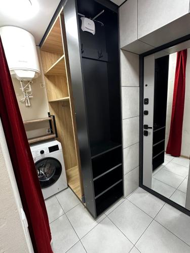 a small bathroom with a washing machine and a mirror at Elegant Apartment City Center in Tiraspol