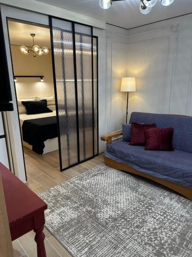 a living room with a blue couch and a bedroom at Elegant Apartment City Center in Tiraspol