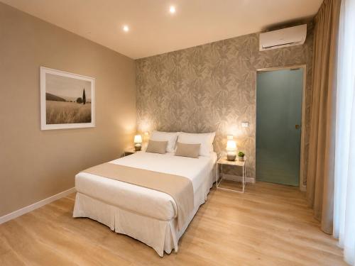 a bedroom with a large white bed and two lamps at Harmony House Prestige in Pisa