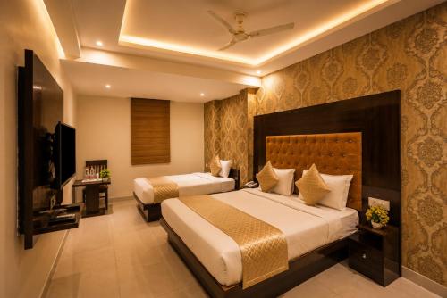 a hotel room with two beds and a television at HOTEL ICONIC At Delhi International Airport in New Delhi
