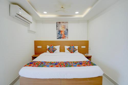 a bedroom with a large bed with a wooden headboard at FabHotel MV Luxury Rooms in Hyderabad