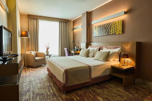 a hotel room with a bed and a television at Avantgarde Urban Levent in Istanbul
